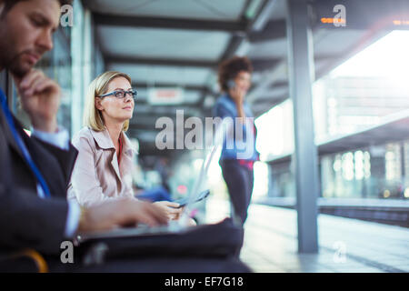 Businessman using laptop in train station Stock Photo