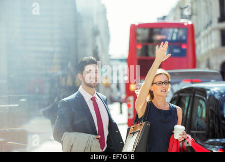 Business people hailing taxi in city Stock Photo