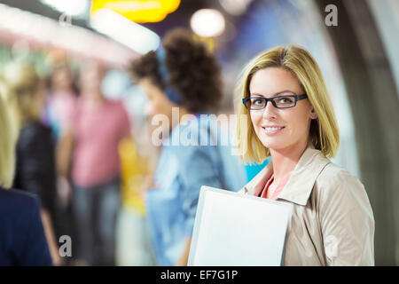 Businesswoman smiling in train station Stock Photo