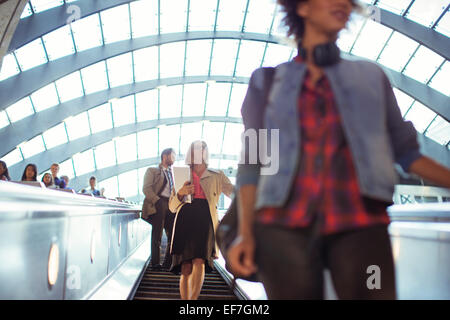 People riding escalator Stock Photo
