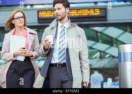 Business people walking and talking in train station Stock Photo