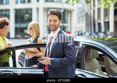 Businessman smiling outside car Stock Photo