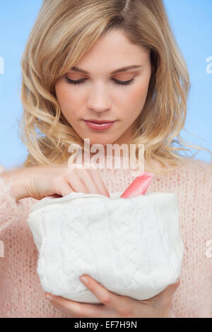 Portrait of a beautiful woman holding a makeup bag Stock Photo