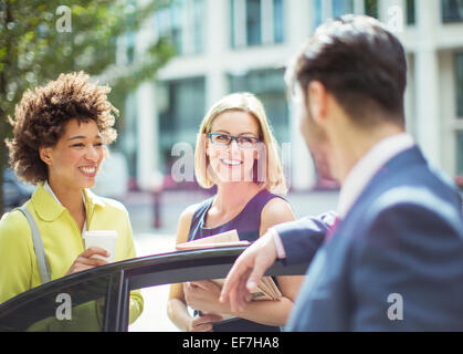 Business people talking near car Stock Photo