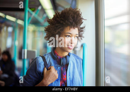 Woman looking out window of train Stock Photo