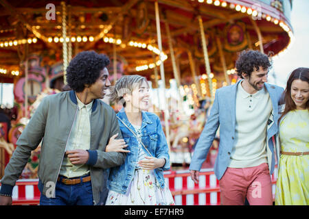 Two couples walking in amusement park and laughing Stock Photo