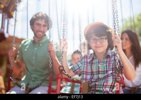 Boy smiling on carousel in amusement park Stock Photo