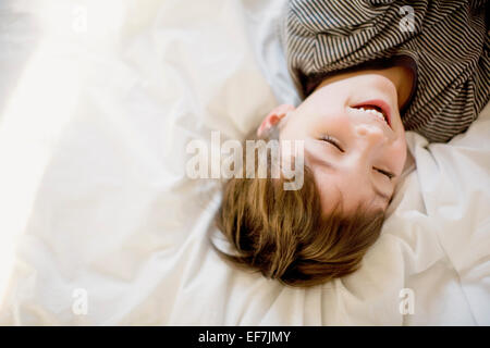 Happy boy lying on the bed Stock Photo