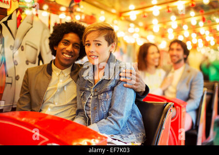 Man embracing scared girlfriend on ghost train Stock Photo