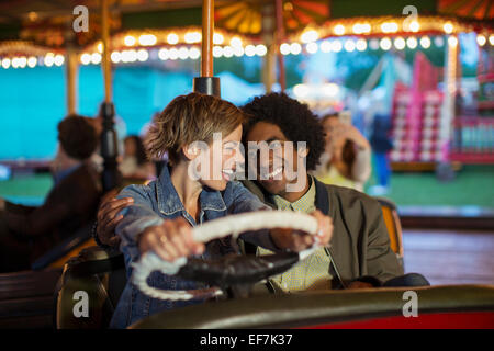 Young couple on bumper car ride in amusement park Stock Photo