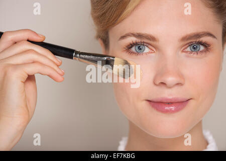 Portrait of a beautiful woman applying foundation Stock Photo