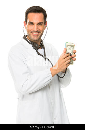 Half length portrait of a male doctor, smiling at camera and using stethoscope on money Stock Photo
