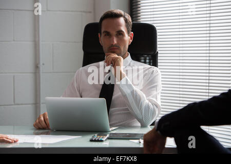 Two businessmen having a meeting in the office using laptop computer and digital tablet Stock Photo