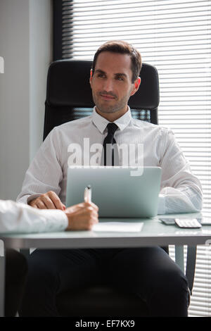 Two businesspeople having a meeting in the office using laptop computer Stock Photo