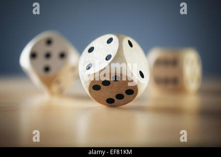 Rolling the dice three dice on wooden desk Stock Photo