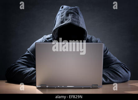 Computer hacker stealing data from a laptop Stock Photo