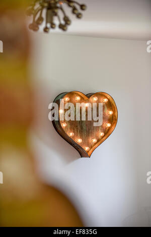A distressed metal effect light in the shape of a heart with lights set around the edgehearth Stock Photo