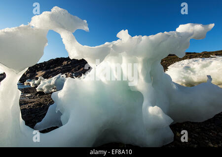 Canada, Nunavut Territory, Setting midnight sun lights melting iceberg stranded at low tide in Frozen Channel at northern edge o Stock Photo