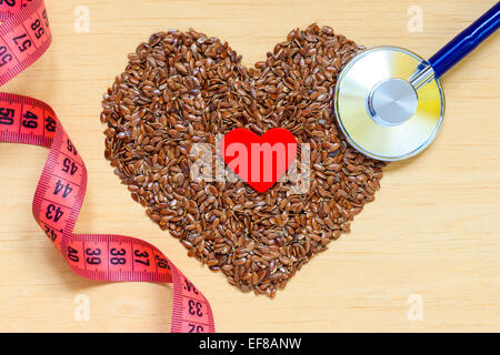 Diet healthcare weight reduction concept. Flax seeds linseed heart shaped stethoscope and measuring tape. Healthy food for preve Stock Photo