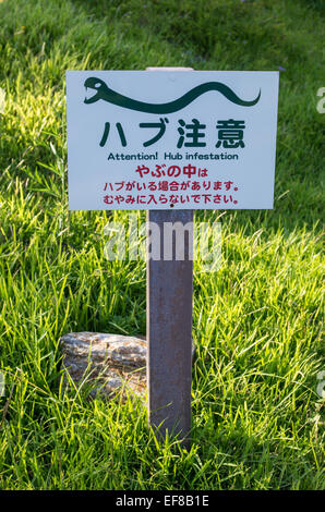 A sign warning of venomous Habu snakes on Tokashiki Island, Okinawa, Japan with a fun 'Engrish' mistake Stock Photo