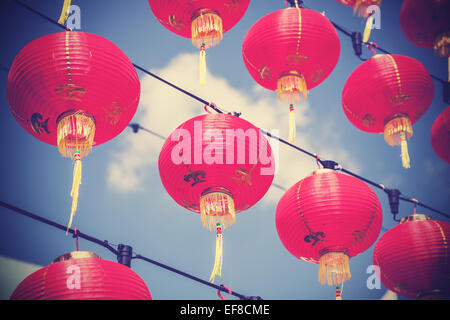 Retro filtered chinese red paper lanterns against blue sky. Stock Photo