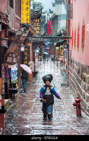 A local Miao woman walks along one of Fenghuang's narrow streets, Hunan Province, China Stock Photo