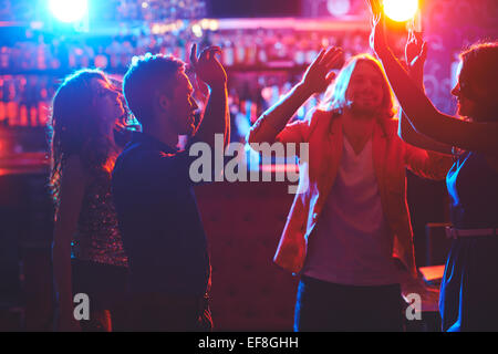 Portrait of happy friends dancing by the bar counter Stock Photo