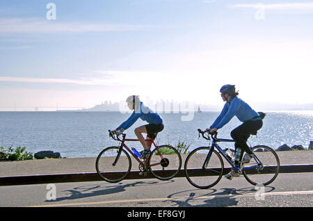 two women bicyclist ride along San Francisco Bay in Sausalito California Stock Photo