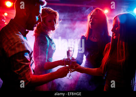 Group of friends with champagne toasting at party in night club Stock Photo