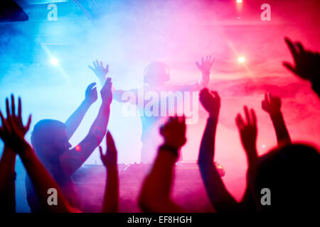 Male deejay in front of dancing crowd Stock Photo