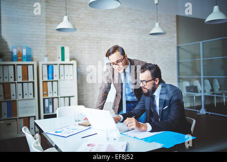 Confident colleagues discussing business project at meeting Stock Photo