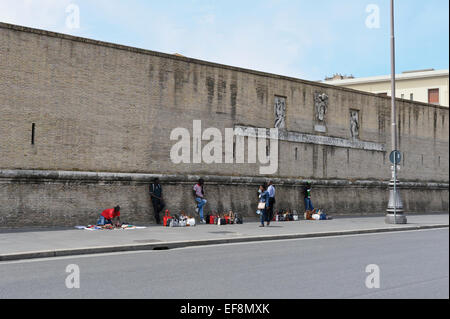 Street vendors selling fake designer handbags by the great wall surrounding the Pope residence in Vatican City, Rome, Italy. Stock Photo