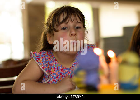 Girl blowing out candles  on her birthday cake Stock Photo