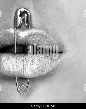 Safety pin through woman's lips Stock Photo