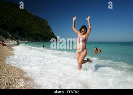 Italy, Marche, Sirolo, Happy pregnant woman on beach Stock Photo