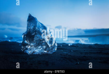 Iceland, Ice cube melting on black sandy beach Stock Photo