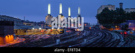 Railway lines in front of Battersea Power Station at dusk, London, England, UK Stock Photo