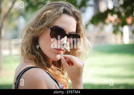 Portrait of young woman smelling flower Stock Photo