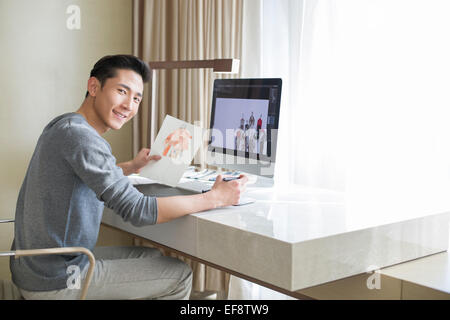 Young male fashion designer working at home Stock Photo