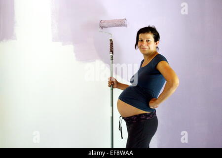Pregnant Woman painting room Stock Photo