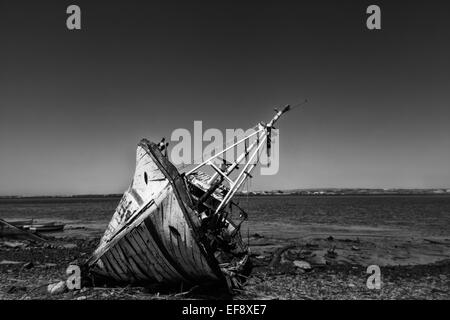 Beyond the need for repair, and old fishing boat sits broken, no longer used for fishing or tourist visits. Stock Photo