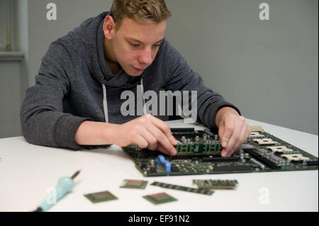 A boy working on the innards of a computer. Photo: Jan Haas Stock Photo ...