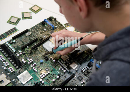 A boy working on the innards of a computer. Photo: Jan Haas Stock Photo ...
