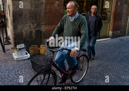 Man cycling in the city centre of Lucca, Tuscany, Italy Stock Photo