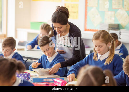 Female teacher with her pupils in classroom Stock Photo