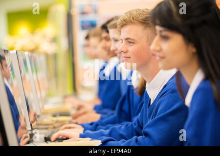 Smiling students using computers in computer room Stock Photo