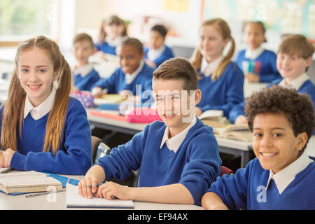 Elementary school children smiling in classroom Stock Photo