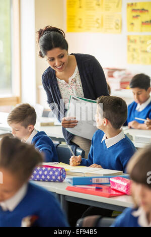 Teacher and elementary school children in classroom during lesson Stock Photo