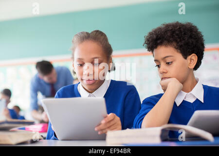 Pupils using tablet pc's in classroom Stock Photo