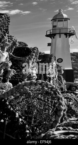 Black and white photograph of old fishing nets in front a small lighthouse in St. Ives, Cornwall. Stock Photo